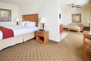 Relax in this inviting space with a comfortable bed, sofa, and ceiling fan.