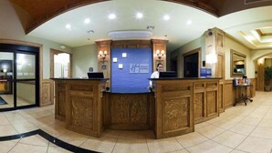 A reception desk with a blue backdrop and a logo, surrounded by wooden paneling and a tiled floor. - Holiday Inn Express & Suites Zapata by IHG (Zapata)