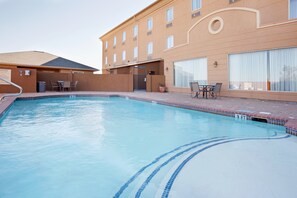 Relax by the pool surrounded by a tiled deck and comfortable seating.