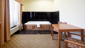 A bathroom with a bathtub, a wooden table, and a chair. - Holiday Inn Express & Suites Zapata by IHG (Zapata)