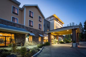 A hotel with a stone facade, a covered entrance, and a sign indicating it is a conference hotel.