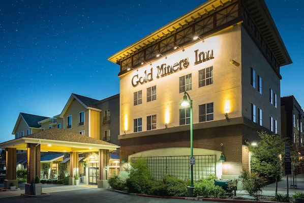 Un hotel llamado "Gold Miners Inn" con un acceso cubierto y fachada de ladrillo.