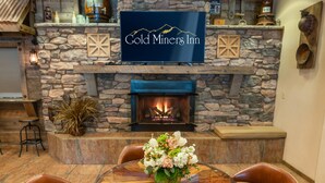 Un camino in pietra con una televisione che mostra la scritta “Gold Miners Inn”.