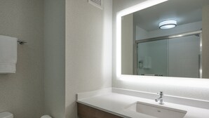 Ein Badezimmer mit einem weißen Waschbecken, einem Spiegel und einer Toilette.