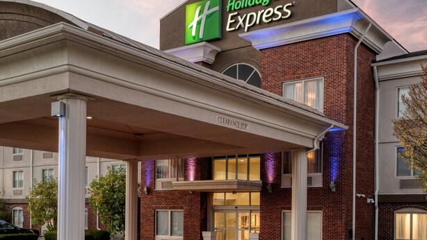 Ein Holiday Inn Express Gebäude mit freiem Zugang, einem überdachten Wartebereich und einer Ziegel-Fassade.