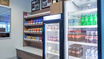 A vending machine stocked with snacks and beverages, including Doritos, Lay's, and Sprite.