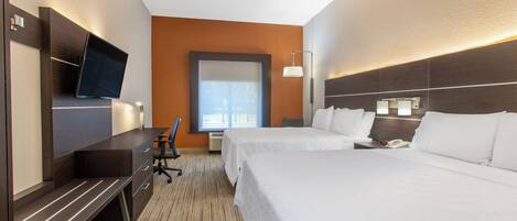 A hotel room with a bed, a desk, a chair, a television, and a window.