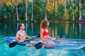 Two people in a kayak on a calm body of water surrounded by dense greenery. - Holiday Inn Express Hotel & Suites Silver Springs - Ocala by IHG (Silver Springs)
