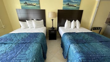 Habitación estándar, 2 camas matrimoniales, vista a la alberca | Tabla de planchar con plancha y wifi gratis