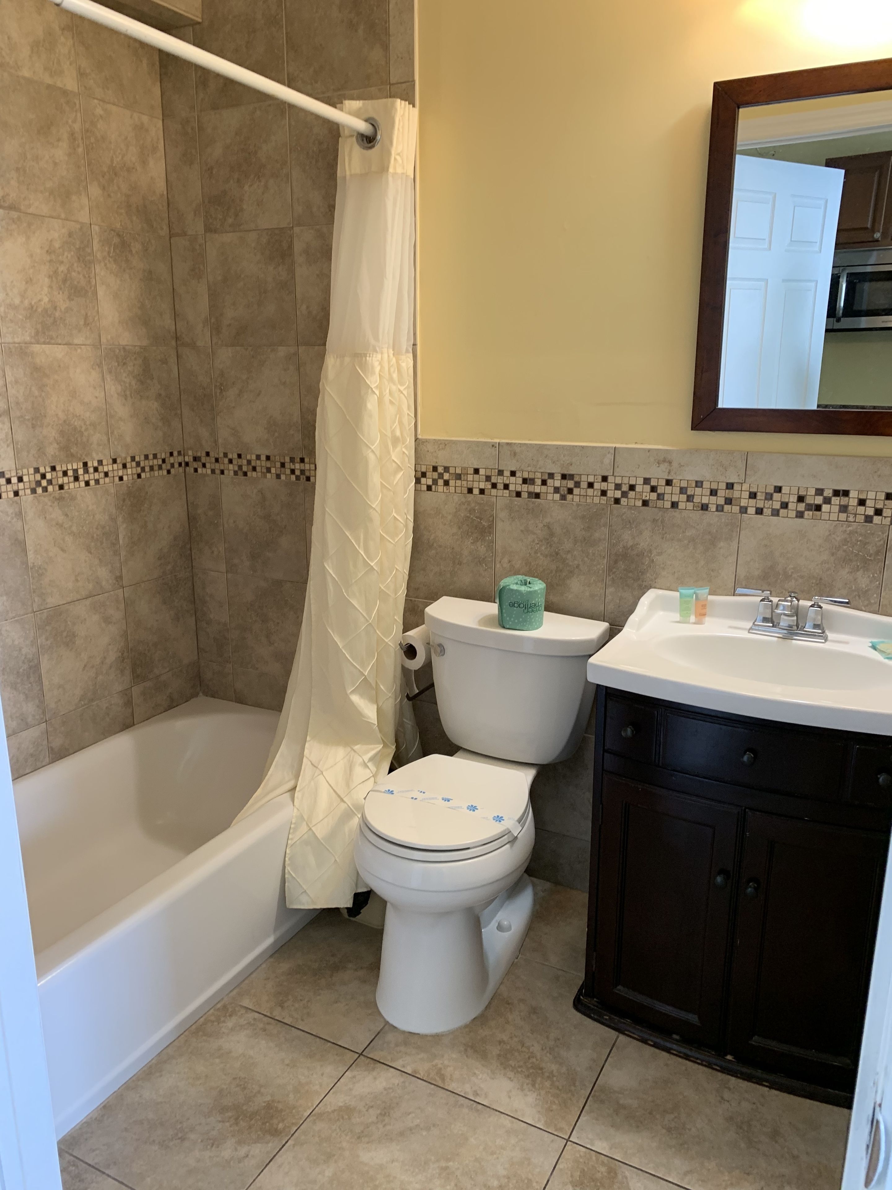 A bathroom with a bathtub, toilet, and sink.