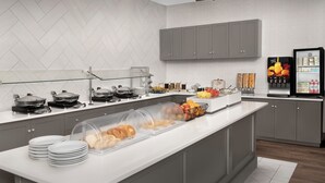 A modern kitchen with a long counter, glass display cases, and a refrigerator stocked with beverages. - Residence Inn by Marriott Bozeman (Bozeman)