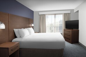 A modern hotel room with a large bed, a flat-screen TV, a wooden nightstand, and a window with curtains. - Residence Inn by Marriott Bozeman (Bozeman)
