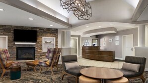 A spacious lobby with a fireplace, comfortable seating, a reception desk, and a modern chandelier. - Residence Inn by Marriott Mt. Laurel at Bishop's Gate (Mount Laurel)