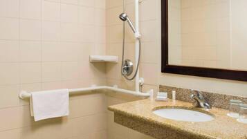 A bathroom with a sink, mirror, and grab bars.