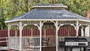 A gazebo with a dark roof and white trim, featuring a grill and outdoor seating. - Candlewood Suites Augusta by IHG (Augusta)