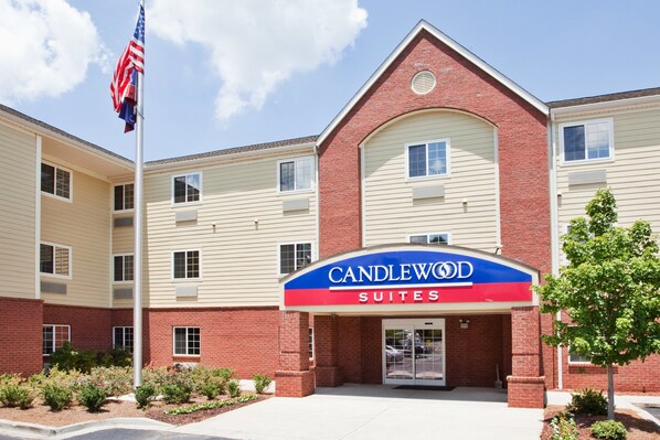 A hotel with a prominent "CANDLEWOOD SUITES" sign, featuring a brick facade and multiple windows. - Candlewood Suites Augusta by IHG (Augusta)
