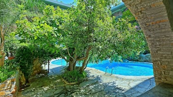 Una piscina al aire libre de temporada, sombrillas