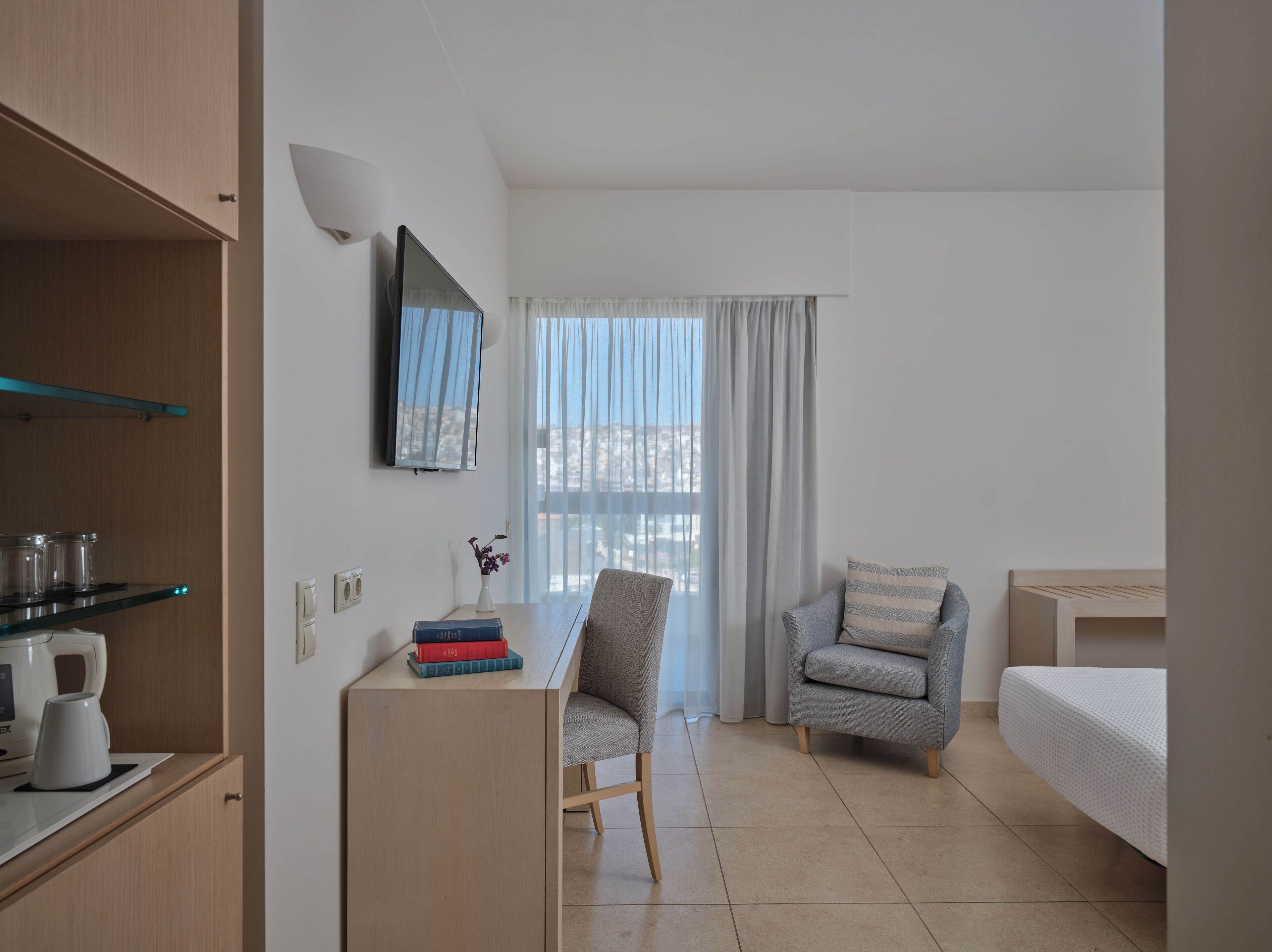 Ein Hotelzimmer mit Schreibtisch, Stuhl, Sofa und einem Bett.