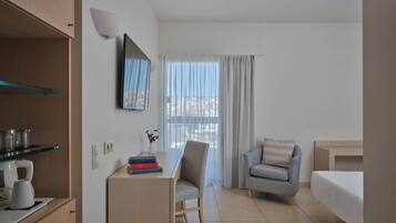 Habitació d'hotel amb escriptori, cadira, sofà i llit.