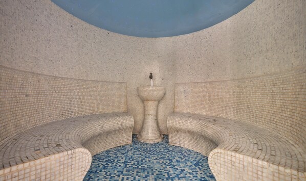 A large, circular room with a mosaic floor and walls, featuring a central fountain. - Sitia Beach City Resort & Spa (Sitia)