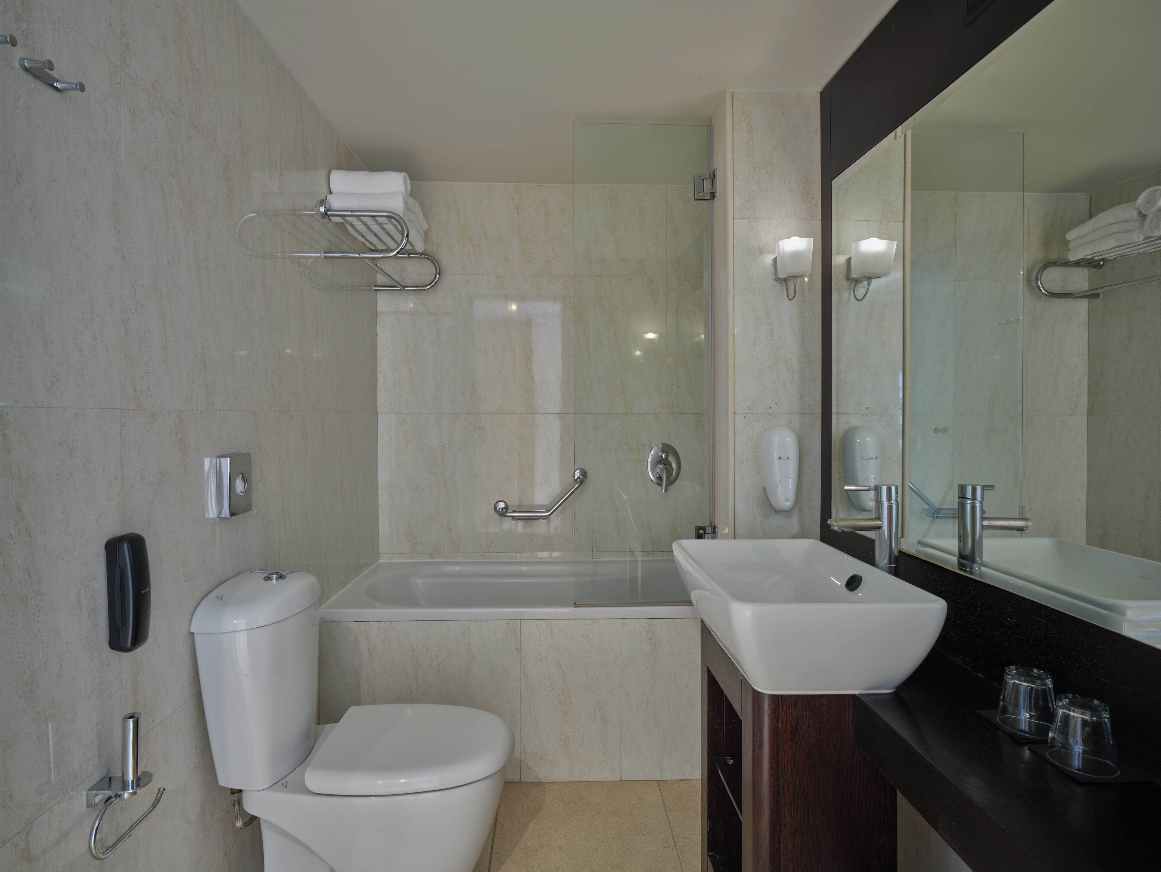 Un baño moderno con inodoro, lavamanos y bañera.