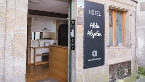 Un edificio de piedra con un letrero que indica Hotel Alda Algalia.