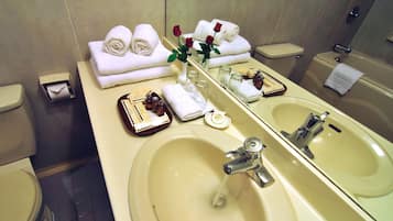 Un baño de hotel con dos lavamanos, un espejo y artículos de aseo.