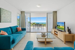 1 Bedroom Ocean View Apartment | Living area | 55-inch TV with satellite channels, DVD player, books