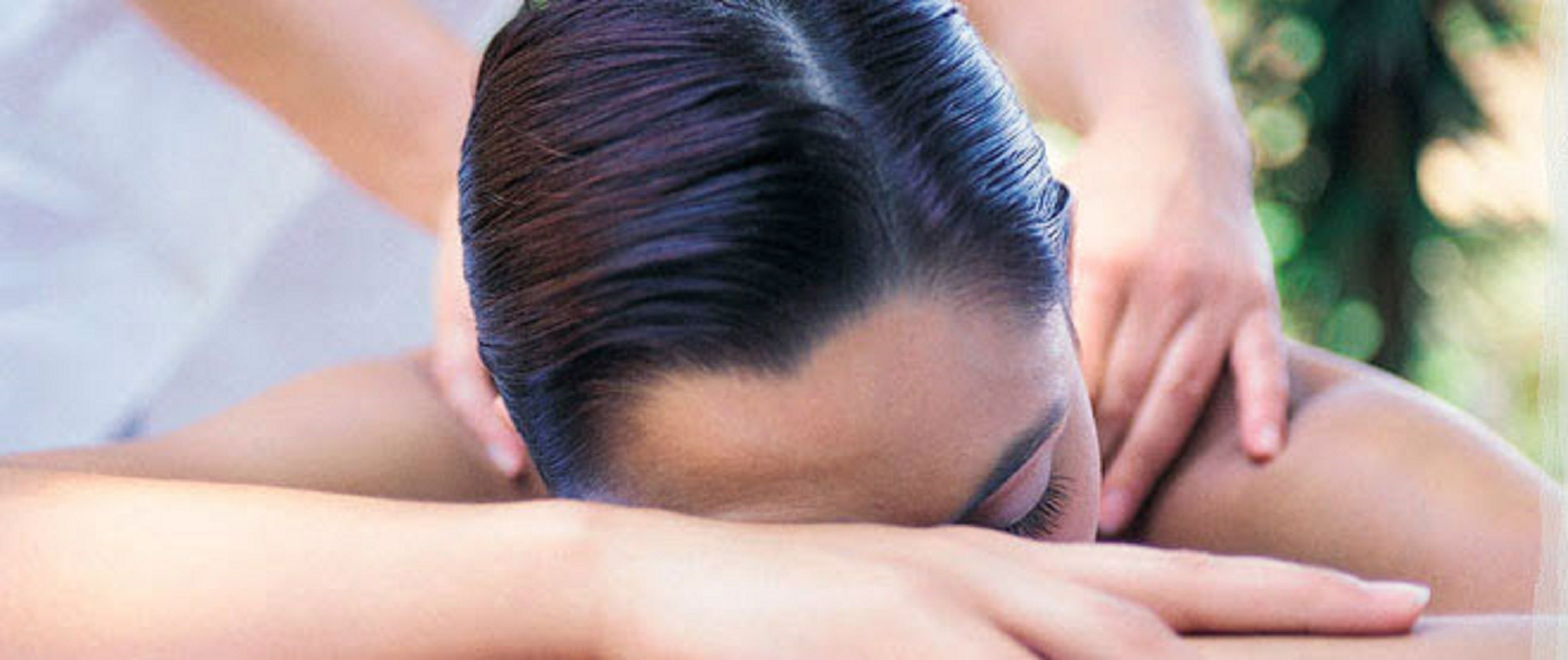 A close-up of a person receiving a head massage.