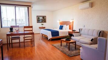 Habitación junior, 1 cama King size | Caja de seguridad en la habitación, escritorio y ropa de cama