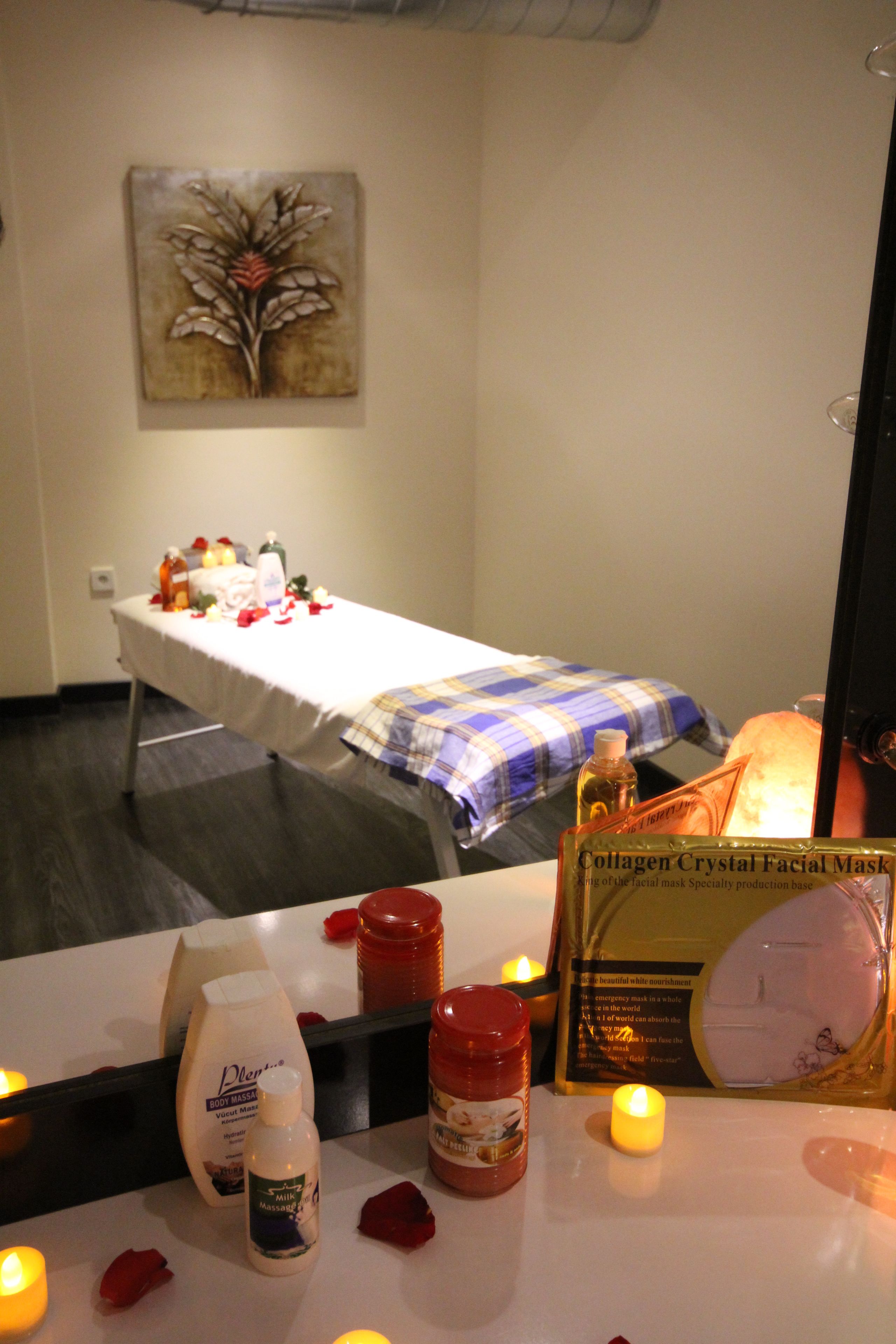 A room with a massage table, candles, and various spa products.