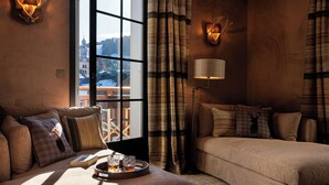 Una habitación acogedora con sofá, cama, lámpara y vistas a un edificio a través de una ventana.
