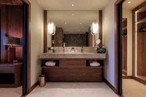 Un baño moderno con tocador de madera, un espejo grande y estantes empotrados.