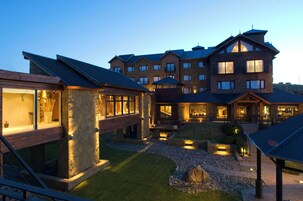 Ein mehrstöckiges Hotel mit einer Steinfassade, mehreren Balkonen und einem gut beleuchteten Außenbereich.