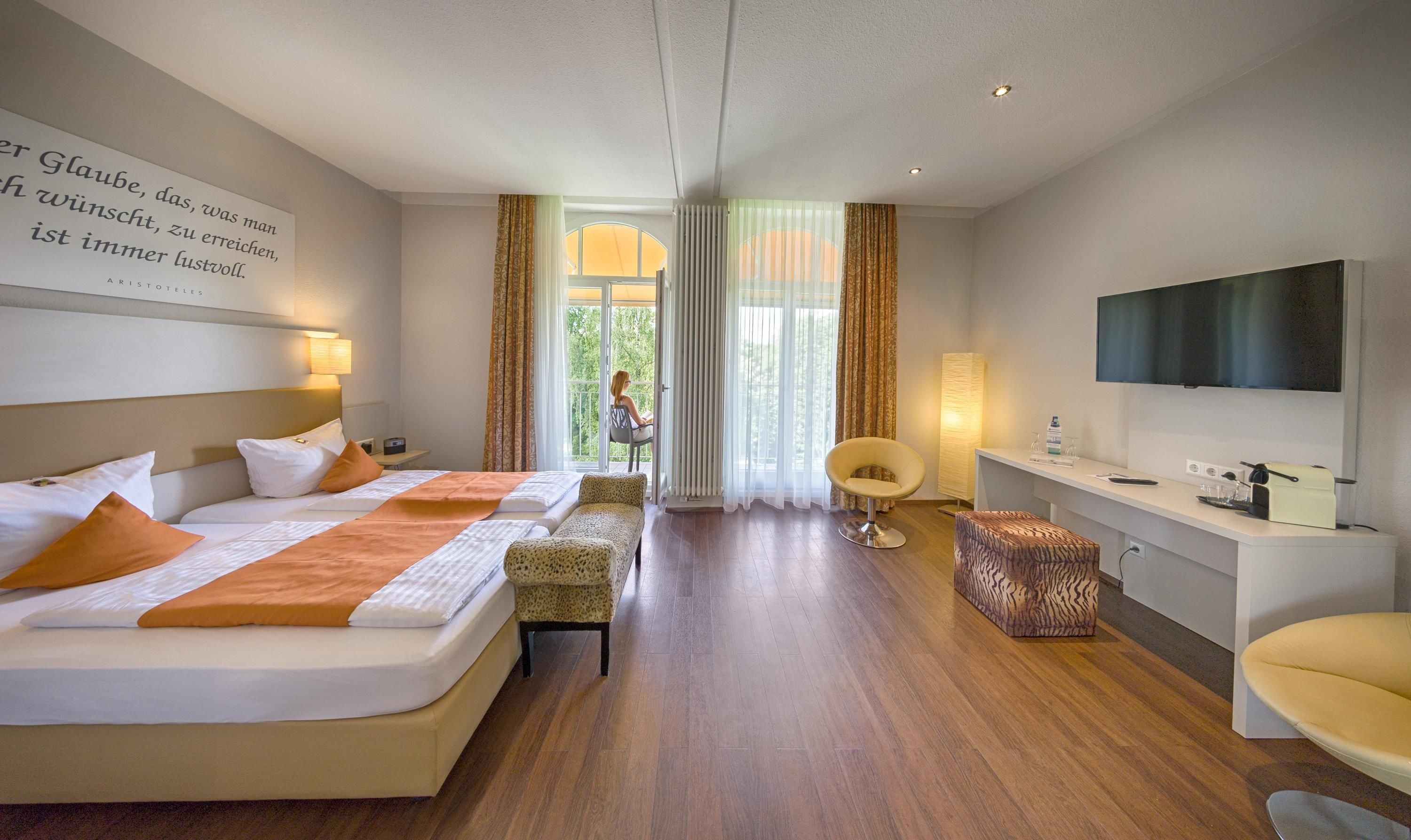 Una habitación de hotel con cama, escritorio, silla y televisor.