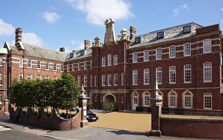 A historic red brick building with multiple windows and a central entrance.
