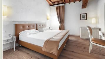 Une chambre à coucher comprenant un lit, des tables de chevet, une chaise, un bureau et une lampe.