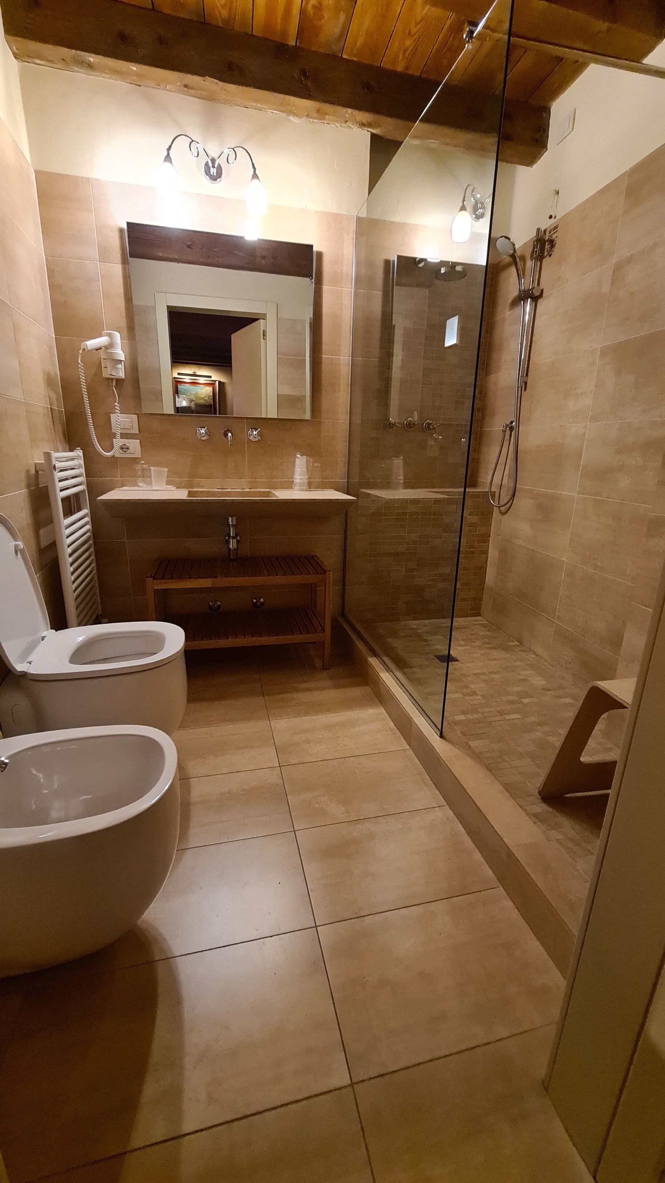 A bathroom with a toilet, sink, and shower area.