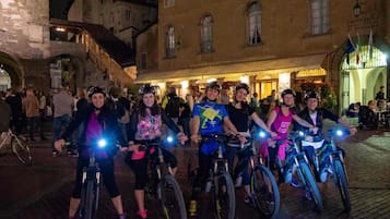 Eine Gruppe Radfahrer auf einer Kopfsteinpflasterstraße bei Nacht.