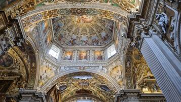 A highly ornate ceiling with intricate frescoes and gold accents.