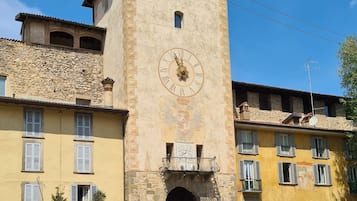 Un bâtiment historique doté d’une tour horlogée, de places assises en plein air et d’une place pavée.
