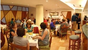 A dining area with multiple tables and chairs, people seated and eating. - Hotel Due Torri (Agerola)