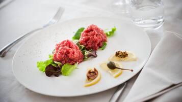 Ein weißer Teller mit Salat, Zitronenscheiben und einem Löffel.