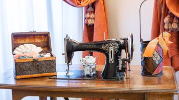 A vintage sewing machine on a wooden table with a decorative box and a small teapot.