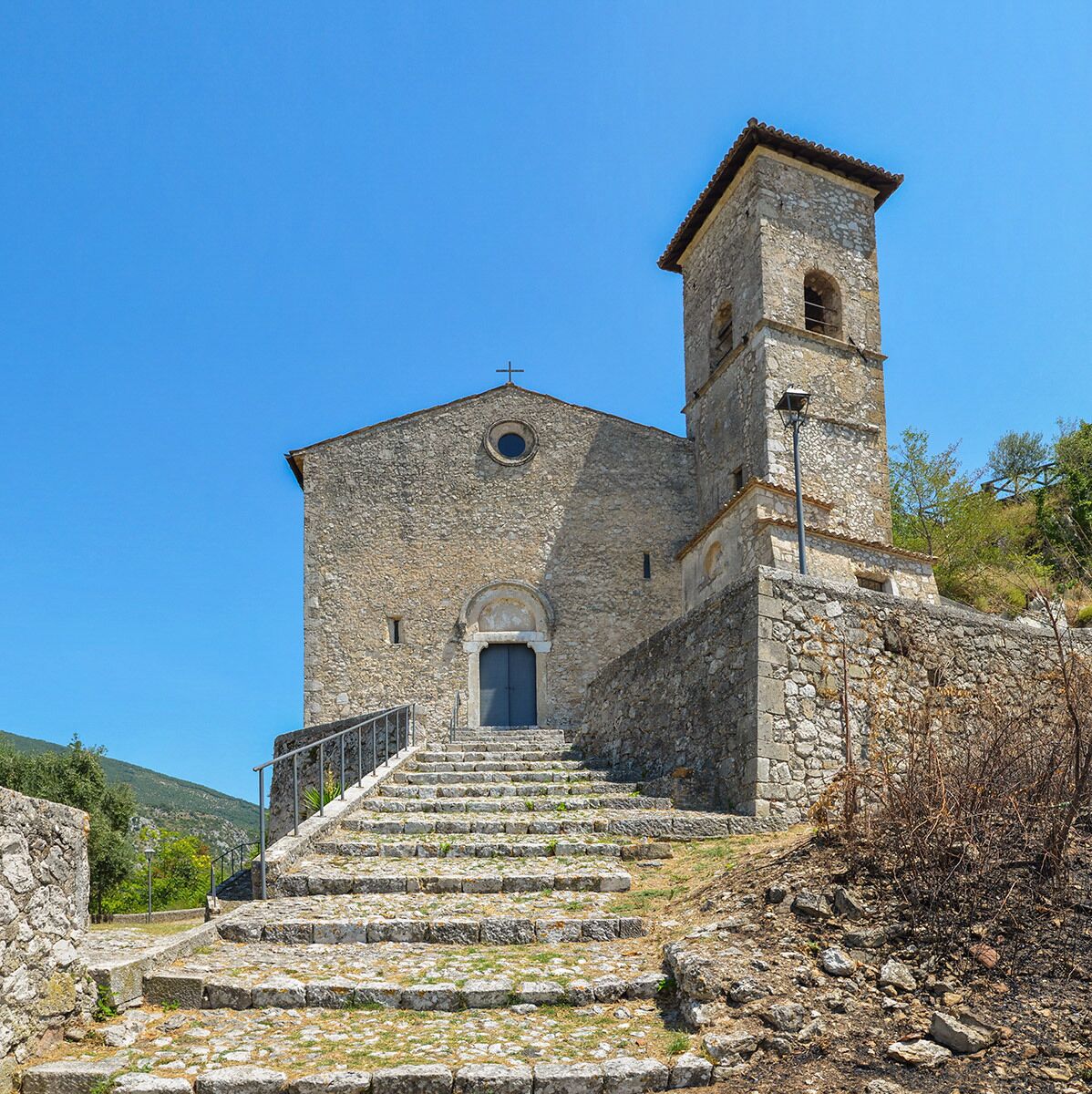 Une église en pierre dotée d’un clocher et d’un escalier menant à l’entrée.