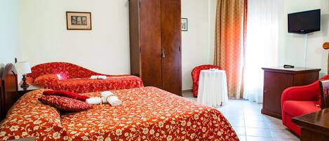 A hotel room with a large bed, a wardrobe, a desk, a television, and a window with curtains.