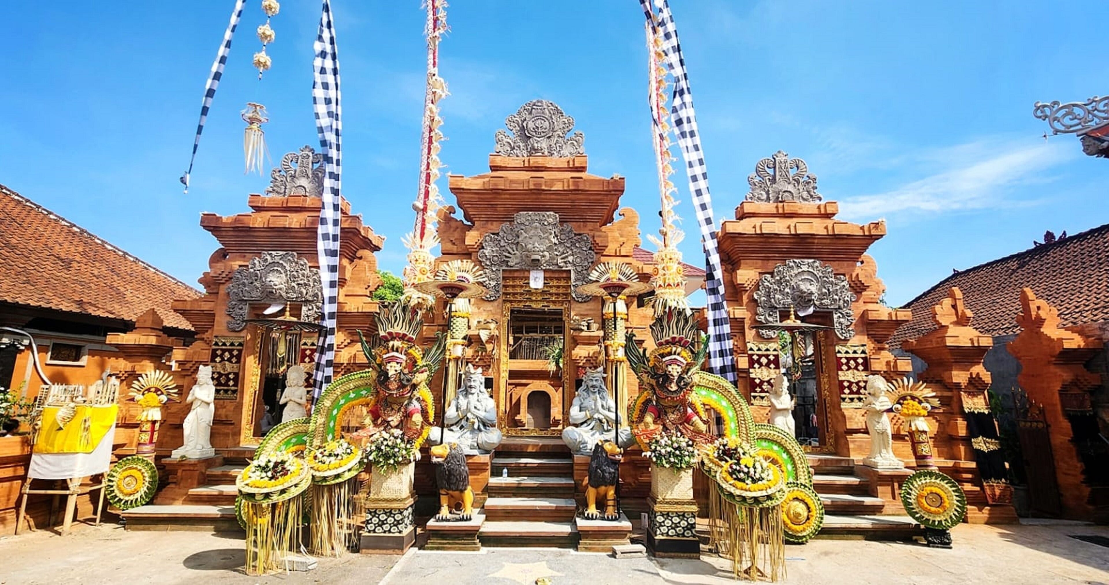 Un templo balinés tradicional con intrincadas esculturas, estatuas y un santuario central.