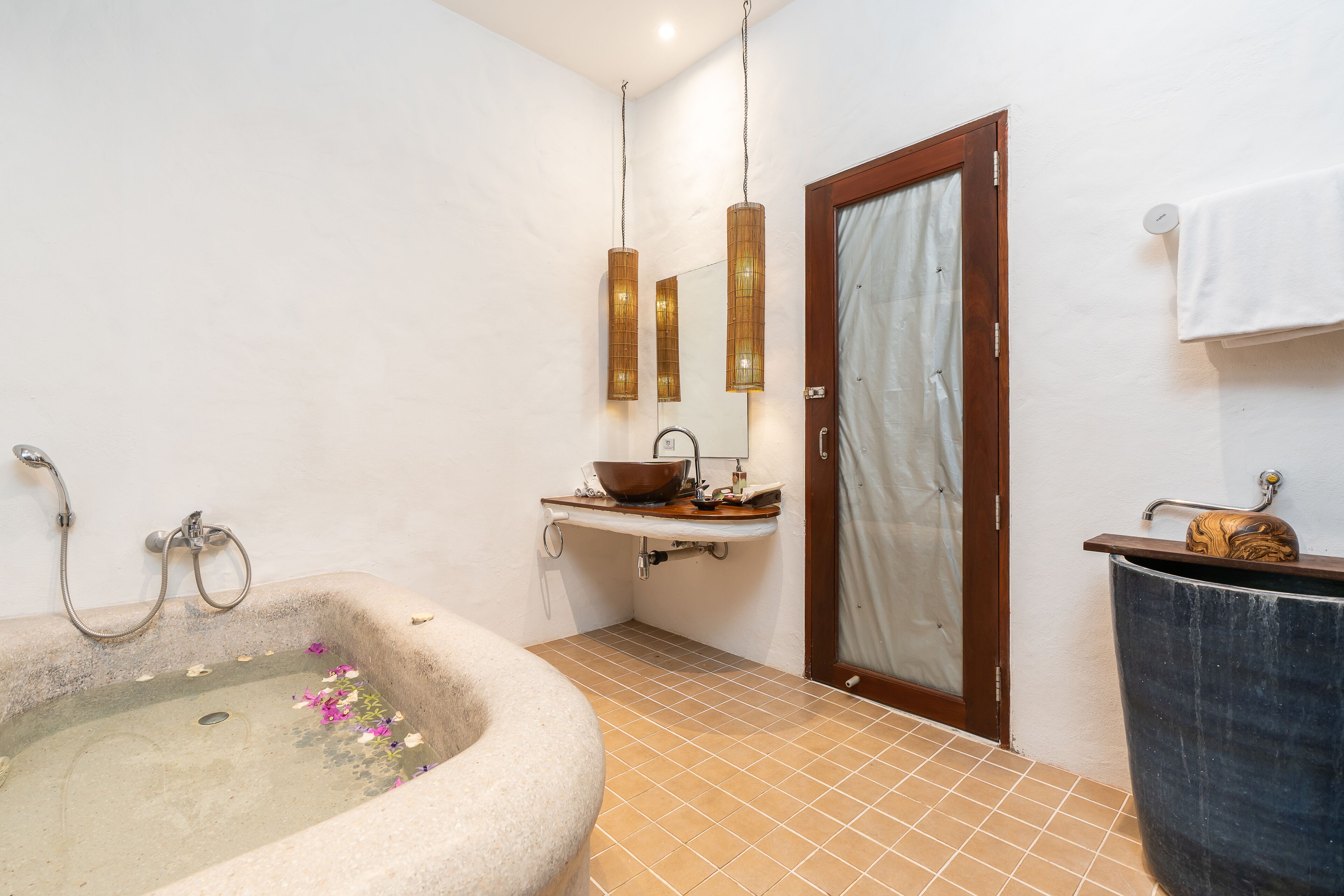 Un baño con una bañera independiente, un tocador de madera y un espejo grande.