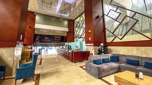 A spacious lobby with a reception desk, a seating area with sofas, and a staircase leading to upper floors. -  Tequendama Suites Bogota (Bogotá)
