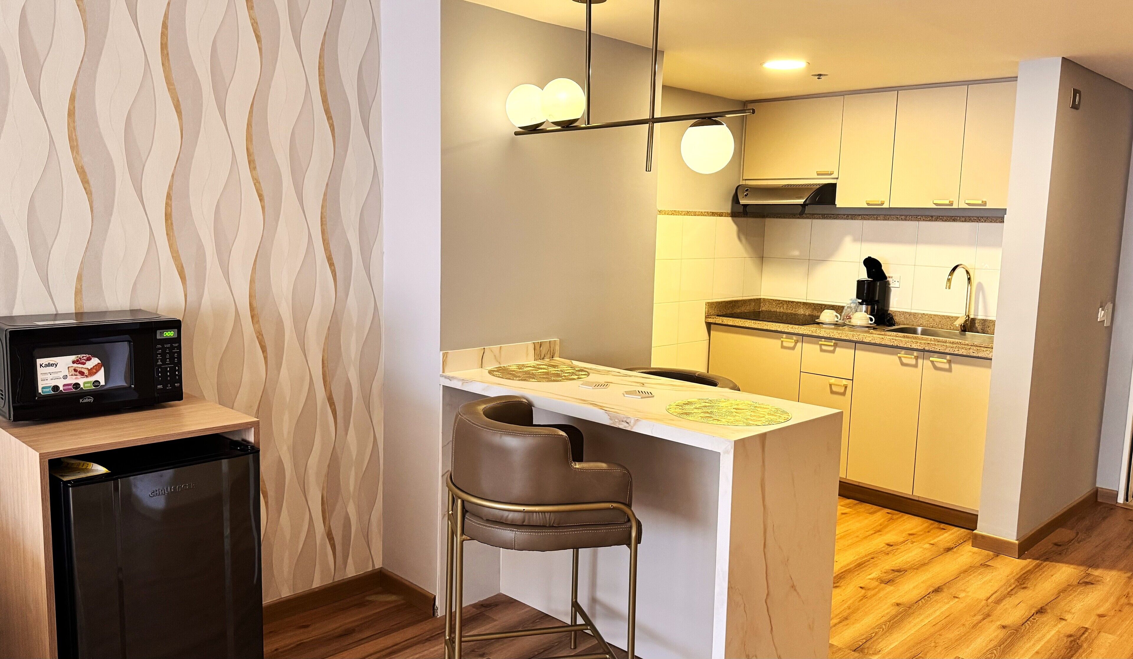 A compact kitchen with a microwave, a coffee maker, and a sink.